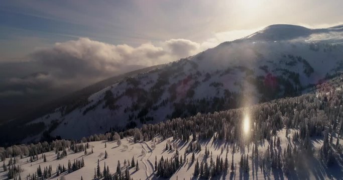 Aerial drone panoramic to the winter mountain views. Epic video of snow forest and rocks in winter. Frosty day on ski resort. Explore the beauty of earth. Scenic image of hiking concept. 4k footage