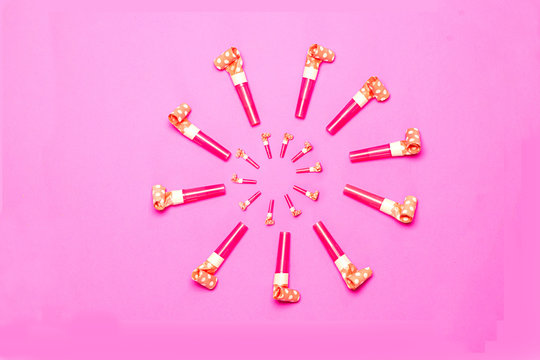 Party Blowers on pink background copy space
