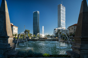 Piazza con fontana con grattacieli sullo sfondo, Milano 3 Torri - obrazy, fototapety, plakaty