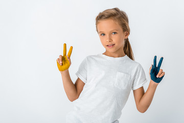 cheerful kid with paint on hands showing peace sign isolated on white