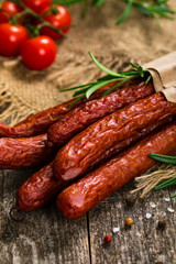 Thin Dry Smoked Polish Sausage on Wooden Background. Selective focus.