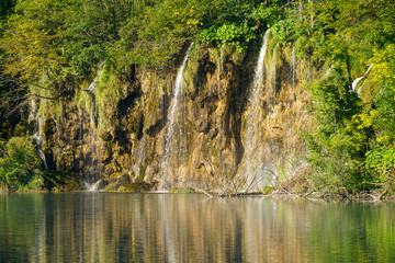 Fototapeta na wymiar View from the ship to the shores and waterfalls of Plitvice Lakes National Park