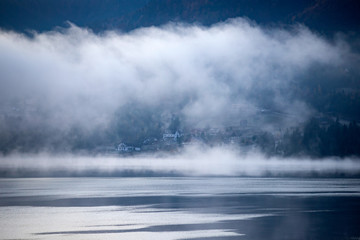 Lovely autumnal landscape with fog over the lake.