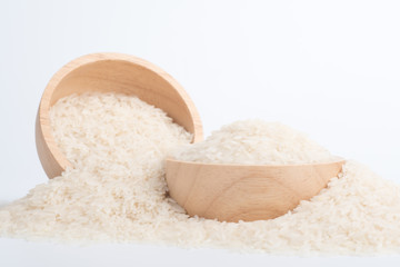 Clean rice grain in a brown wooden bowl on a white background.