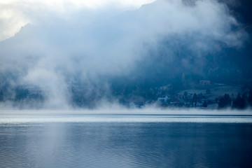 Lovely autumnal landscape with fog over the lake.