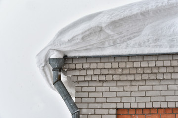 Snow on the roof of a brick house after heavy snowfall. Night scene