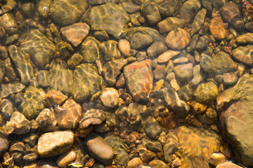 Stones under water, wet river stones background