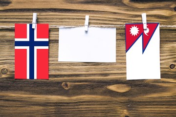 Hanging flags of Bouvet Islands and Nepal attached to rope with clothes pins with copy space on...