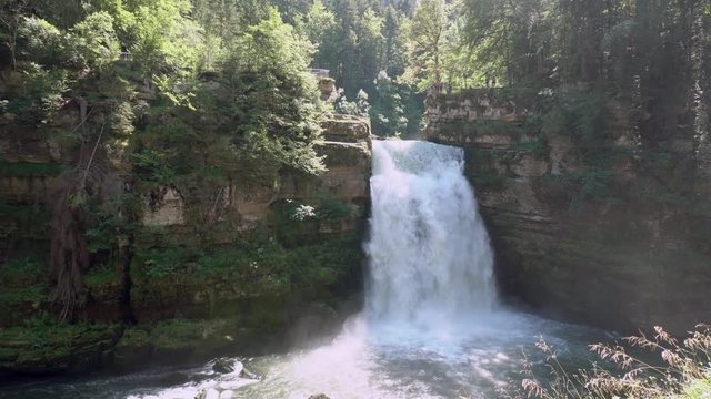 Slow pan right shot of beautiful swiss waterfall,during sunshine