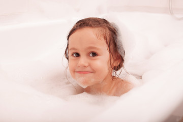 happy funny kid laughing and bathed in the bath
