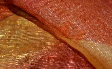 the texture of the background of the nylon fabric with iridescence from yellow to light brown