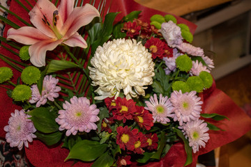 A bouquet of different chrysanthemums and fragrant lilies is an amazing decoration of any celebration