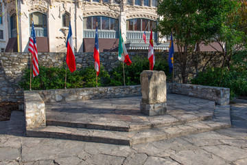 The Alamo Mission flags monument in downtown San Antonio, Texas, USA. The Mission is a part of the San Antonio Missions World Heritage Site.