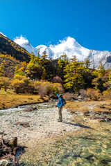 tourist at top of mountain at outdoors during a hike the summit of mountain peak. Success freedom and happiness achievement in mountains. Active sport concept
