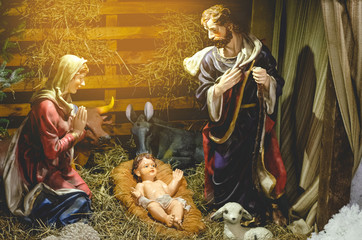 Fototapeta na wymiar Christmas nativity scene represented with porcelain figures of Mary, Joseph and baby Jesus. nativity scene. Selective focus, noise effect