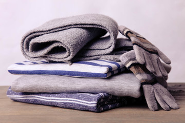 A stack of sweatshirts, a scarf and gloves