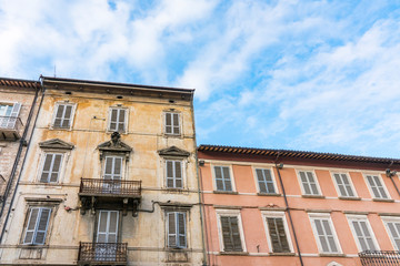 Fototapeta na wymiar brown and pink apartments with shutters in Ascoli Piceno, Italy