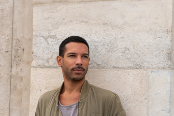 Obraz premium portrait of young man leaning against stone walll
