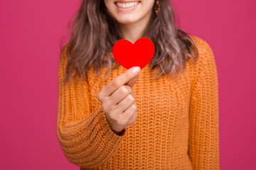 Happy woman holding red heart made from paper