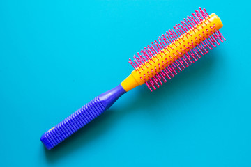 Colored round comb on a blue background