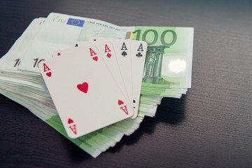 Pile of money euro with poker cards on top, aces