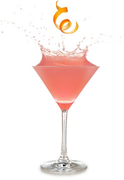 Orange Rind Falling Into A Splashing Pink Cocktail Isolated On White