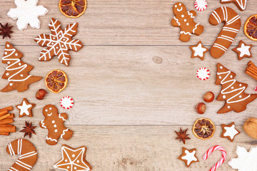 Christmas gingerbread cookies, candy and baking items. Top view double side border on a wood background with copy space.