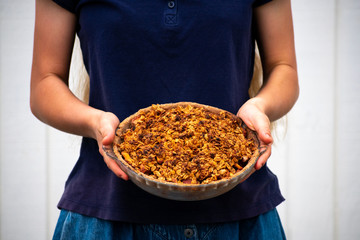 a modest young woman holding a pie