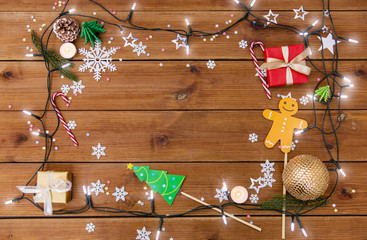 christmas and holidays concept - electric garland and decorations on wooden background