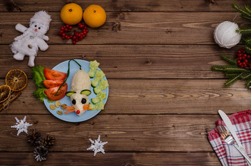 Edible rat made of rice and vegetables is the symbol of 2020 for the festive New Year and Christmas table with copy space . Idea for decorating holiday dishes. How nice to serve vegetables and salad.