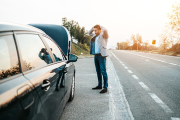 Car issue breakdown or engine failure. Elegant middle age man waiting for towing service for help...