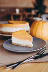 Piece of pumpkin homemade cake. Festive dessert concept. pumpkin tart on cozy cafe background, selective focus, noise effect