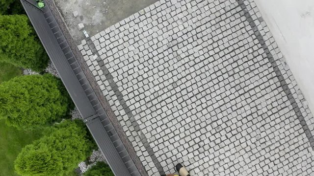 Caucasian Construction Worker Finishing Granite Decorative Brick Road. Residential Bricks Driveway Building.