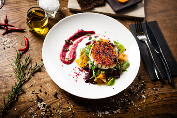 Grilled goat cheese salad served on a plate in restaurant
