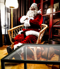 Saint Nicholas is sitting in an armchair. Interior of a luxury home. Table corner with empty space for your gifts. Christmas and magic time