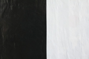 Black and white gloss paper posters glued on street billboard.