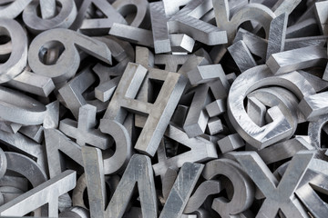 pile of silver metal alphabet characters cutted by waterjet machine