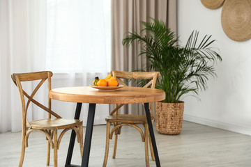 Stylish room interior with dining table and chairs