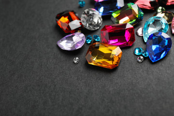Different beautiful bright gemstones on black background