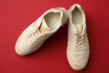 Pair of stylish shoes on red background, top view