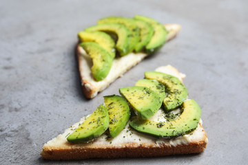 Tasty avocado toasts on light grey table, closeup