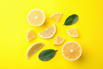 Fototapeta na wymiar Fresh lemons and leaves on yellow background, flat lay