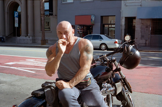Man smoking cigarette while sitting on motorcycle, Mission District, San Francisco