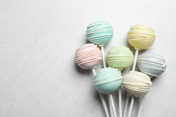 Obraz premium Sweet colorful cake pops on light grey background, flat lay