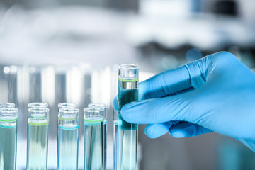 Doctor holding test tube with sample for analysis in laboratory, closeup