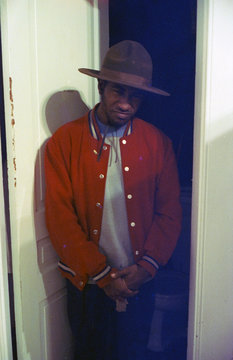 Young man wearing varsity jacket and ranger style hat, San Francisco