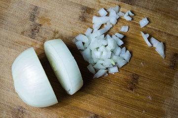 White onion on a wooden board. vegetable slicing process. cooking food