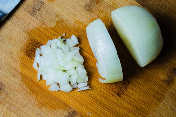 White onion on a wooden board. vegetable slicing process. cooking food