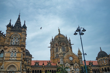 Fototapeta premium front view of mumbai central railway station during dark grey moody cloudy day with bird flying over, a city landmark