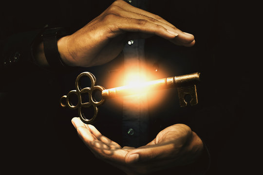 Close up image of a business person holding a shining key. Success business concept